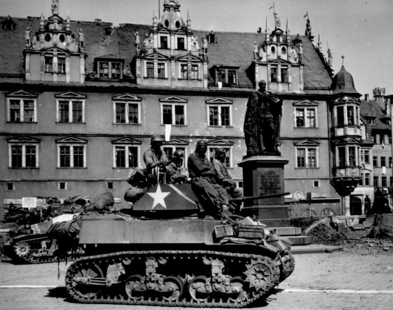 U.S. light tanks stand by awaiting call to clean out scattered Nazi machine gun nests