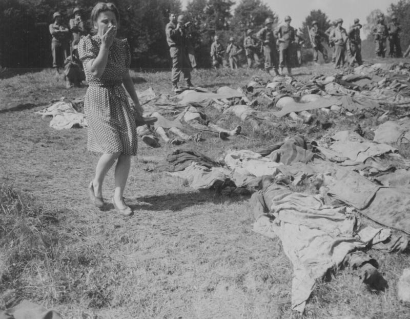 A German girl is overcome as she walks past the exhumed bodies