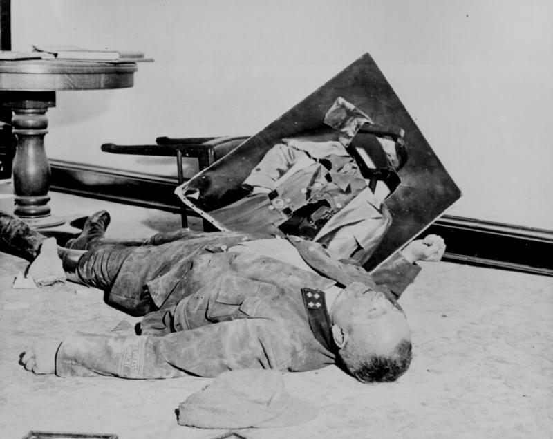 A dead general of the Volkssturm lies on the floor of city hall