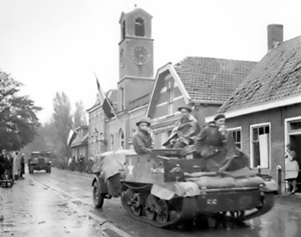 Canadian Royal Hamilton Light Infantry carriers moving through the Dutch village of Krabbendijke