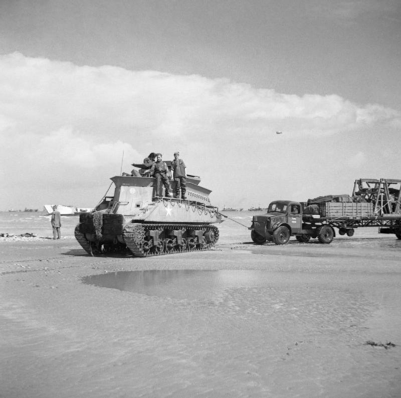 Sherman BARV tows a disabled Bedford articulated lorry and trailer off the beach.