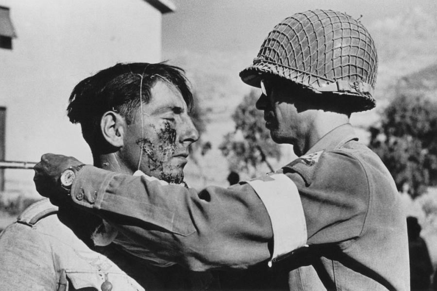 Photo by Robert Capa, member of the American Medical Corps treats a German prisoner of war