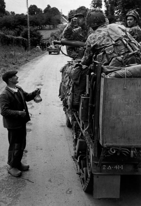 Photo by Robert Capa, French farmer offers cider to American soldiers